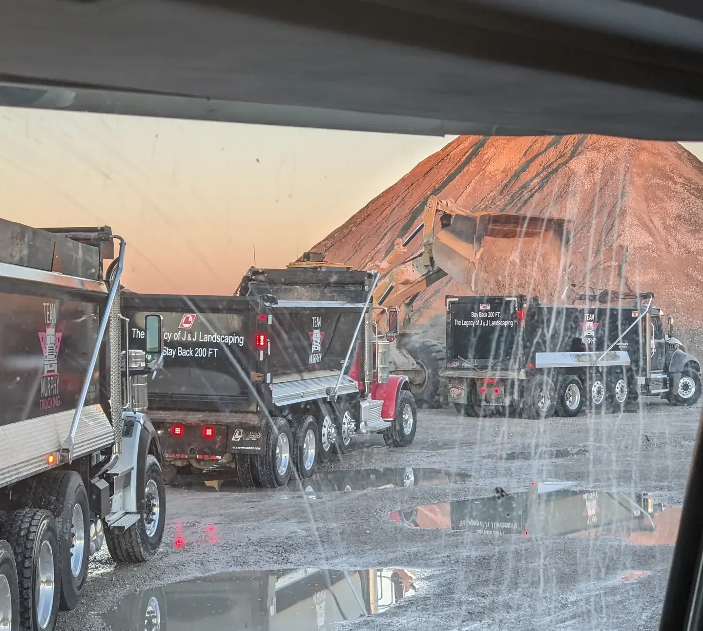 A truck driving down the road with other trucks.