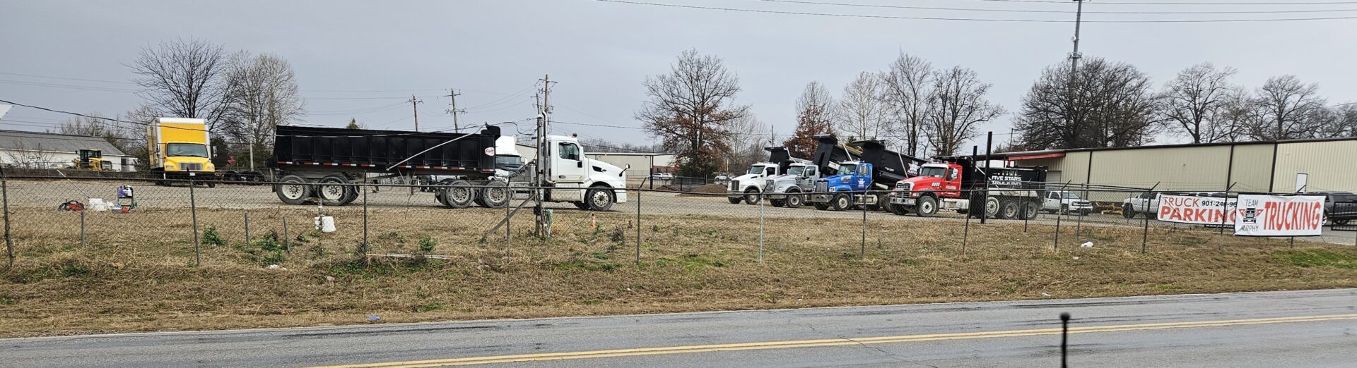 A group of trucks parked on the side of a road.